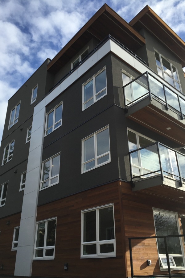 The exterior of 300 Menzies Street, a commercial property, designed by Alan Lowe Architecture with dark paint, silver trim, and horizontal wood features.