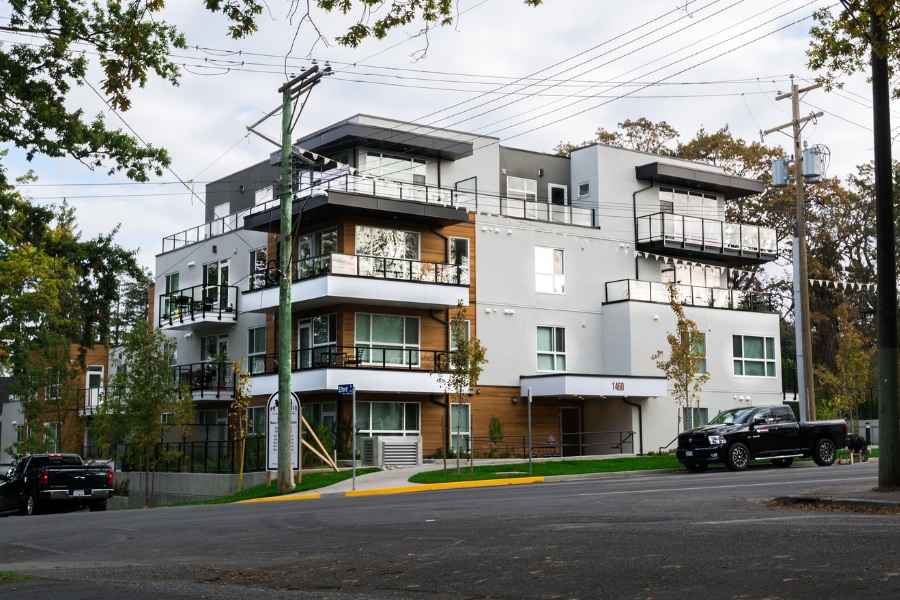 Elford and Pandora Condos, in modern white and grey siding with horizontal wood accents and patios.