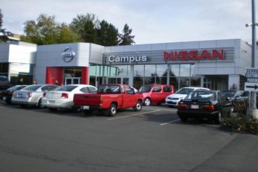 The exterior of Campus Nissan commercial property, designed by Alan Lowe Architecture with contemporary grey siding and large signage.