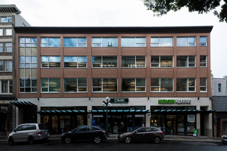 The exterior of Argus Building on Fort Street, a commercial property, designed by Alan Lowe Architecture with brick and windows on the top three levels, with commercial spaces with glass and metal awnings on the first level.