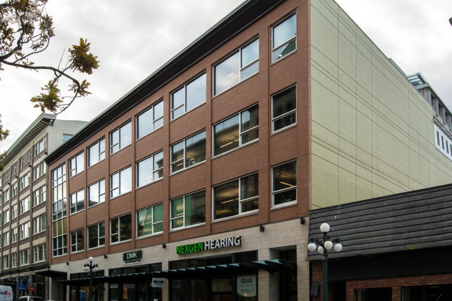 The exterior of Argus Building on Fort Street, a commercial property, designed by Alan Lowe Architecture with brick and windows on the top three levels, with commercial spaces with glass and metal awnings on the first level.