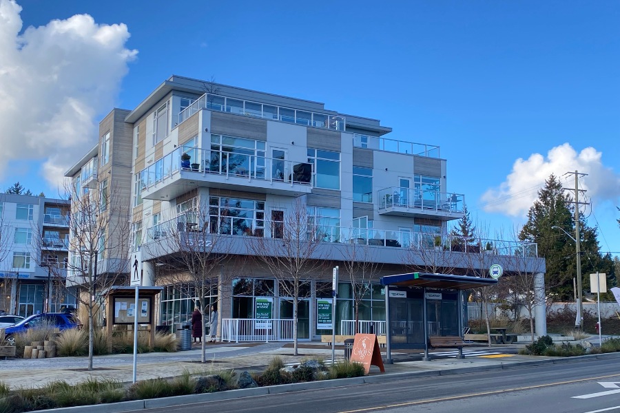 The exterior of Cordova Bay Shopping Center, a commercial property, designed by Alan Lowe Architecture with commercial spaces on the first level, and residential properties on the top three levels.
