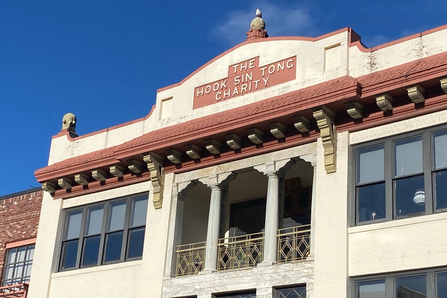 The exterior of Hook Sin Tong Building, a commercial property, designed by Alan Lowe Architecture with red and white stone exterior and brick features.