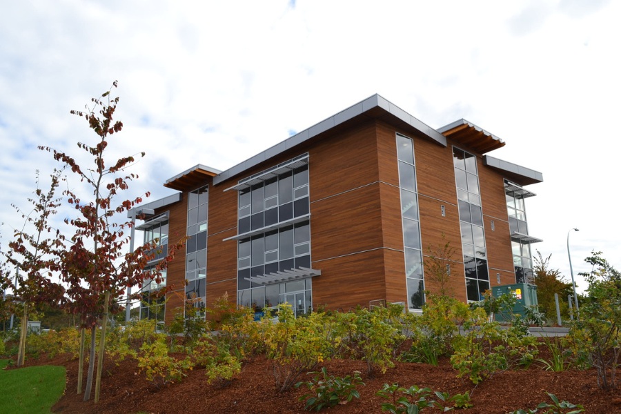The exterior of King Lasik commercial property, designed by Alan Lowe Architecture with contemporary horizontal wood siding, large windows and angled roof with wood features.