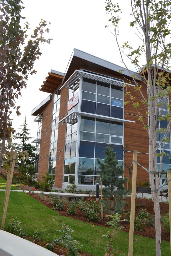 The exterior of King Lasik commercial property, designed by Alan Lowe Architecture with contemporary horizontal wood siding, large windows and angled roof with wood features.