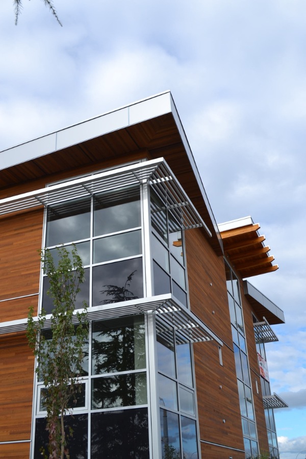The exterior of King Lasik commercial property, designed by Alan Lowe Architecture with contemporary horizontal wood siding, large windows and angled roof with wood features.