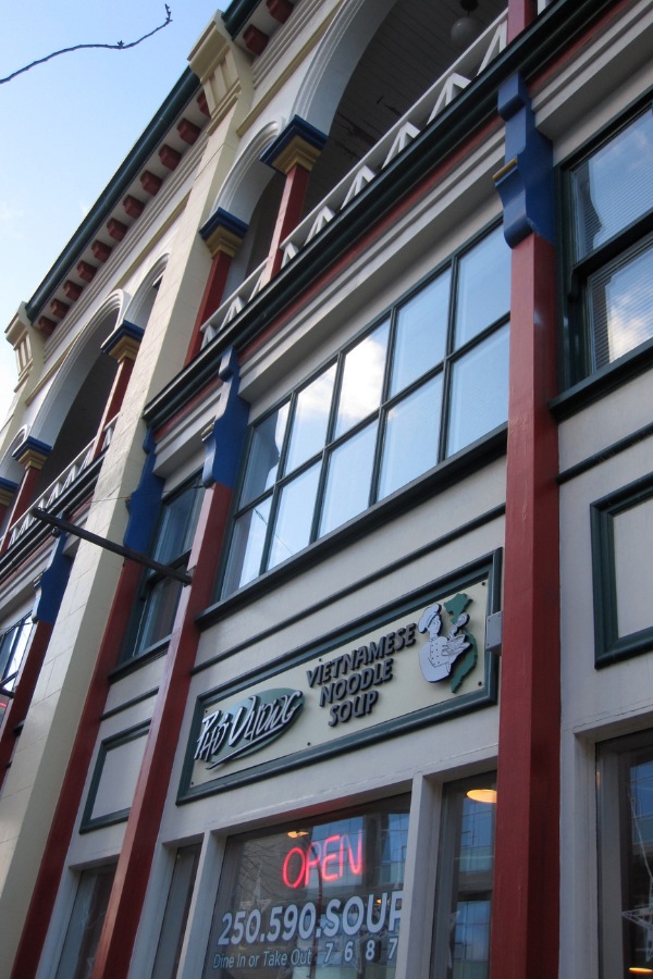 The exterior of a Gee Tuck Tong Building, a commercial property, designed by Alan Lowe Architecture, with blue, red and white traditional siding.