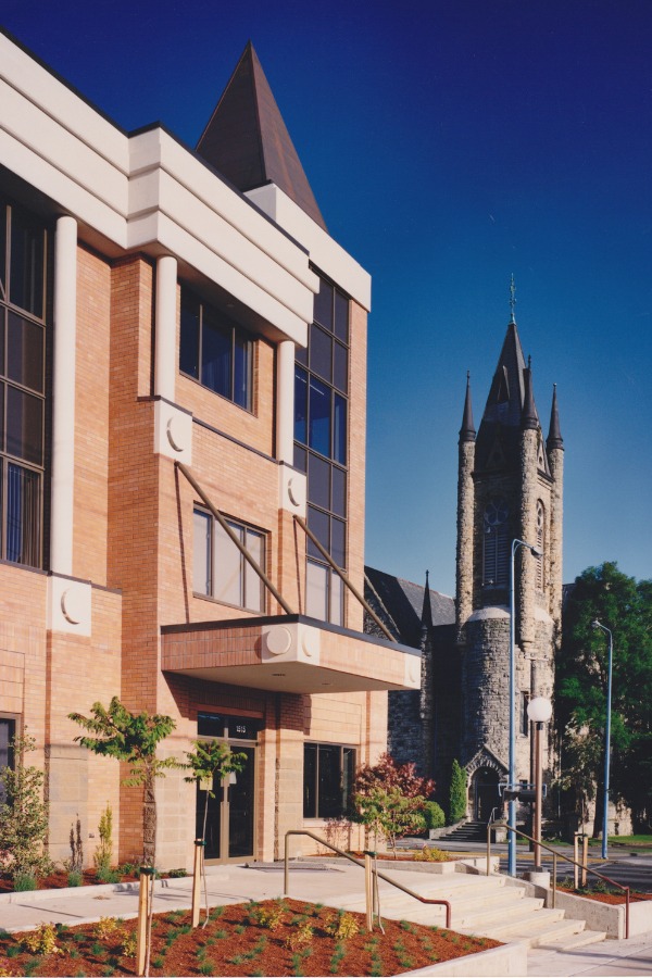 The exterior of the Vefra Building, a commercial property, designed by Alan Lowe Architecture with light brick exterior, stairs leading to an entrance and a tapered roof.